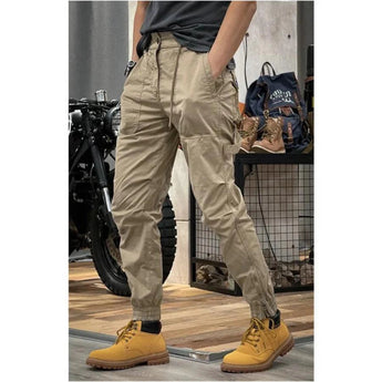 Men wearing khaki slim fit tactical cargo pants in size 4XL, showcasing multiple pockets, durable fabric, and stylish design. The pants are paired with casual footwear, highlighting mobility from the knees to the waist.