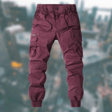 Men's tactical cargo pants in wine red, size 3XL, featuring durable, water-resistant fabric with multiple pockets, showcased on a model highlighting the pants' fit and design.