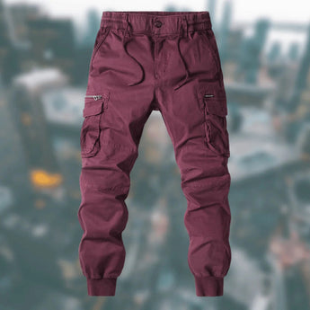 Men's tactical cargo pants in wine red, size 3XL, featuring durable, water-resistant fabric with multiple pockets, showcased on a model highlighting the pants' fit and design.