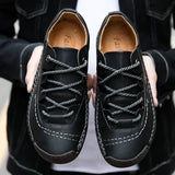 Men's tan leather sneakers with hand-stitched detailing, designed for durability and breathability, displayed on a human leg.