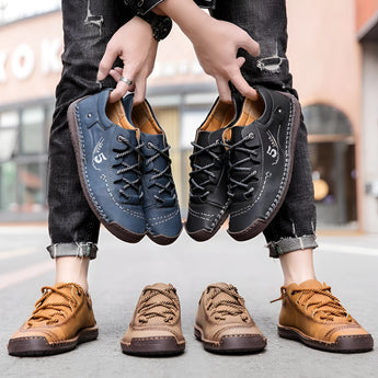 Men's tan leather sneakers with hand-stitched detailing, shown from a side angle on a white background.