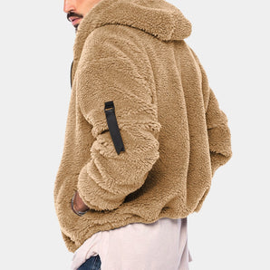 Men's tan teddy bear hoodie made of faux fur fleece, featuring a zip-up design and comfortable fit. The jacket has a beige hue with long sleeves and a soft texture, providing warmth and style for casual wear.