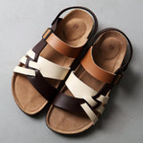 Men's brown two-tone leather sandals with adjustable strap and cork sole, size 47, displayed on a wooden surface.