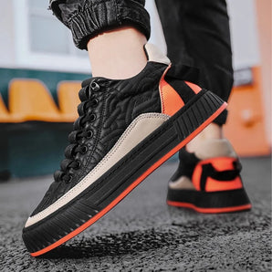 Men's urban black sneakers with contrast orange detailing, featuring a cushioned heel and ribbed sole.