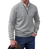 Men's light gray cashmere quarter-zip sweater worn by a model, showcasing the neck and sleeve details, styled for casual winter fashion.