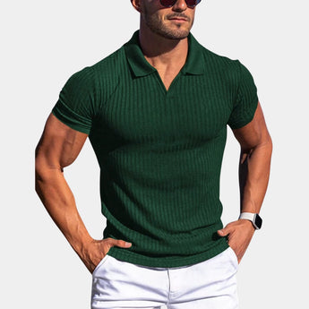 Men wearing a green slim fit stretch cotton polo shirt in size 2XL, showcasing an athletic and breathable design. The man has a muscular build, accessorized with a watch and sunglasses, and features a beard.