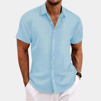 Men's light blue XXL short sleeve cotton dress shirt with white stripes, featuring a classic collar and a comfortable fit, ideal for summer wear. The shirt is displayed on a model wearing a watch on their arm.