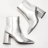 Metallic silver high heel ankle boots showcasing a sleek and trendy design, perfect for making a fashion statement; styled with comfort in mind and available in size 45.