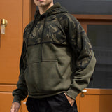 Men's streetwear military green tactical camo hoodie with a zip pocket, featuring a camouflage pattern, long sleeves, and a collar.