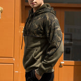 Men's military green tactical camo hoodie featuring a zip pocket, long sleeves, and a high collar, displayed against an urban backdrop.