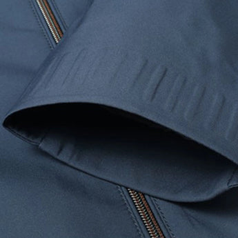 Minimalist dark blue men's bomber jacket with a sleek design, featuring a collar and long sleeves, showcasing a lightweight urban fashion style.