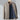 Men's minimalist dark blue bomber jacket with a lightweight design, featuring a sleek collar and long sleeves, styled in an urban fashion setting.