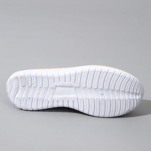 Minimalist white sneaker with seamless design and lightweight sole, featuring a stylish athletic look suitable for casual wear, highlighted by its comfortable and sleek appearance.