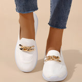 Minimalist white sneaker with a seamless design and lightweight sole, worn on a human leg, showcasing the shoe's sleek and modern appearance.