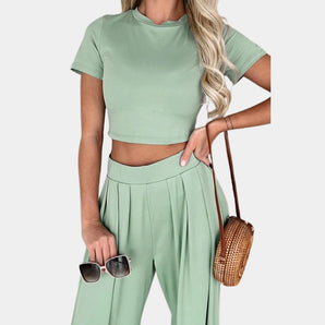 Mint green crop top and high-waisted pleated trousers set with short sleeves showcased on a model, highlighting the outfit's stylish design and fit.