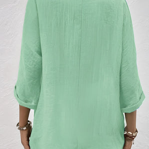 Mint green linen blouse with lightweight fabric, featuring pleated details and 3/4 sleeves, styled elegantly for a fashionable look.