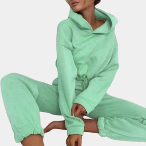 
A mint green pastel loungewear set featuring a crop hoodie with long sleeves and matching sweatpants.