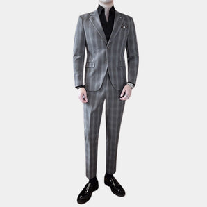 Modern grey slim fit three-piece designer suit featuring a striped pattern. The ensemble includes a blazer, waistcoat, and trousers, with a classic dress shirt visible under the coat. The suit showcases a sleek collar and tailored sleeves, embodying sophisticated formal wear.