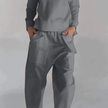 Modern white lace-up blouse paired with high-waist designer grey pants, showcasing the stylish design suitable for workwear or casual settings.