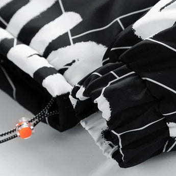 Monochrome geometric print jacket with a high neck, worn by a person. The jacket features long sleeves and is styled for urban winter wear. The image emphasizes the jacket's black and white design, showcasing both style and functionality.