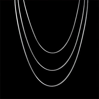 A multi-layer minimalist silver necklace with crescent and circular pendants, shown in a dark background.