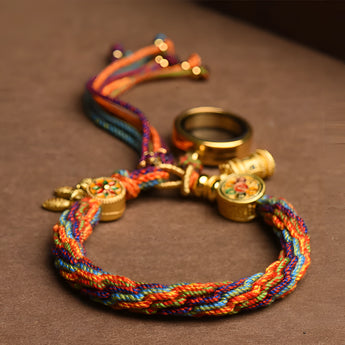 Multicolor boho braided bracelet with ethnic charm, adjustable tassel, and intricate red and multicolored patterns.