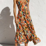 
A woman wearing a multicolor feather print strapless maxi dress, ideal for bohemian summer wear. The vibrant dress features a flowy design, highlighting the shoulders and arms, perfect for a fashionable and relaxed style.