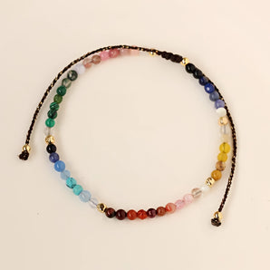 Multicolor gemstone bracelet and necklace set featuring natural materials, designed for chakra healing and holistic wellness.