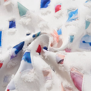 Multicolor patchwork fabric featuring a textured surface and frayed edges, showcasing a variety of patterns with hues of aqua and electric blue, suitable for DIY crafts and creative projects.