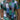 Men's multicolor patchwork polo shirt in vibrant summer fashion featuring shades of blue and green, styled with short sleeves and a classic collar, displayed on a mannequin.