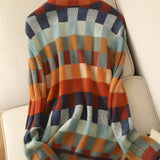 A woman wearing a multicolor plaid turtleneck sweater with long sleeves, featuring a cozy autumn knit design.