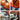 Multicolor plaid women's turtleneck sweater featuring an orange, grey, and multicolored tartan pattern, long sleeves, and a cozy knit fabric perfect for autumn.