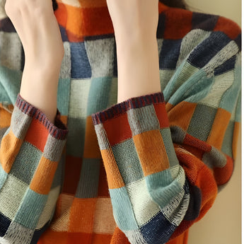 Woman wearing a multicolor plaid turtleneck sweater with long sleeves, showcasing a cozy autumn knit design in orange tones.