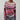 A handmade bohemian knitwear sweater featuring multicolor stripes, prominently showcasing shades of rosa and magenta. The sweater is made from wool, with a charming pattern that includes grey elements. It features a collar and long sleeves, providing a cozy fit, and is available in size 3XL.
