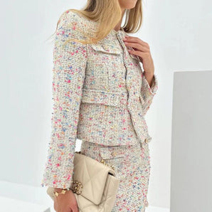 Luxury designer women's workwear featuring a multicolor tweed jacket and skirt suit, showcasing outerwear with structured shoulders, dress shirt collar, long sleeves, and a grey and beige color palette.