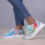 Women's multicolor breathable lightweight athletic sneakers worn by a person, paired with blue denim jeans.