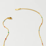 Multicolored gemstone necklace featuring various vibrant beads, an original YA-CHAN design with gold wire accents, displayed on a neutral background.