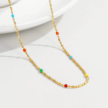 A multicolored gemstone necklace with a gold chain, featuring various beads and artistic patterns, elegantly crafted as part of YA-CHAN Original Gold & Bead Jewelry collection.