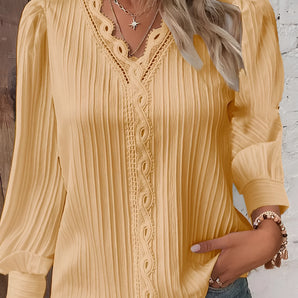 A mustard-colored women's long sleeve blouse featuring lace details and ruffles, with a focus on the neckline and shoulder area.