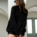 Mustard yellow cable knit turtleneck sweater in a chunky design, suitable for autumn fashion, shown on a person indoors near a window, wearing sunglasses and showcasing the sweater's detailed knit pattern on the neck and sleeves.