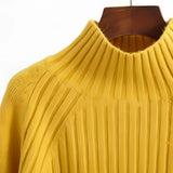 Mustard yellow pleated turtleneck sweater with long sleeves, showcasing cozy winter knitwear design.