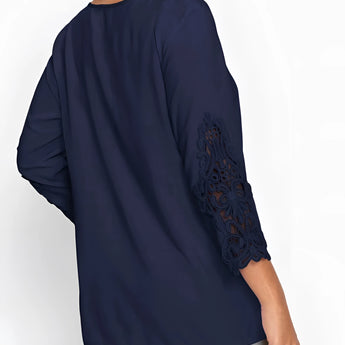 Navy blue women's blouse featuring elegant floral lace sleeves, with a round neckline and a fitted waist.