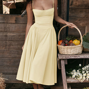 Navy blue fit and flare midi dress with spaghetti straps, suitable for summer wear, displayed on a mannequin against a white background with floral accents.