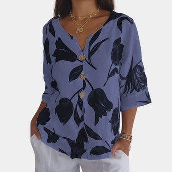 Navy blue floral linen blouse with a V-neck design, featuring short sleeves and a comfortable fit, suitable for a casual summer look for women.