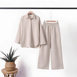 Navy blue linen casual two-piece summer suit for mature women, featuring a beige color in size 5XL, displayed on a clothes hanger against a neutral grey background. The suit has a fashionable design with a focus on the sleeve and collar details.