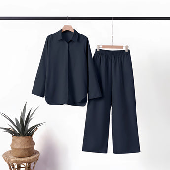 Navy blue linen summer suit consisting of a casual two-piece set for mature women, featuring a dark blue blazer with sleeves and a collar, displayed on a clothes hanger.