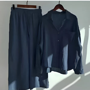 Navy blue men's cotton pajama set featuring an elastic waist and button-up shirt, displayed on a clothes hanger.
