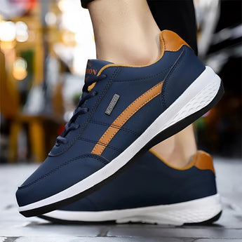 Navy blue men's dual-tone sneakers with a cushioned sole, designed for urban fashion. The athletic shoes feature a stylish blend of electric blue accents, perfect for walking and sportswear activities.