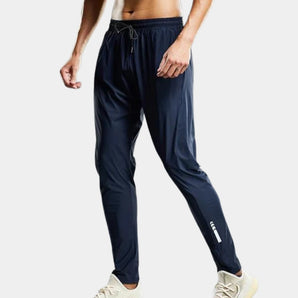 Navy blue men's lightweight joggers featuring a moisture-wicking fabric, designed for athletic activities. The pants include an elastic waist and tailored fit through the thigh and knee, suitable for sportswear fashion.