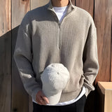 
Alt Text: A navy blue men's ribbed zip-up sweater displayed on a mannequin, showcasing its cozy fall fashion design. The sweater features a high collar, long sleeves, and a zip-up front, suitable for layering over a white dress shirt for a polished look.